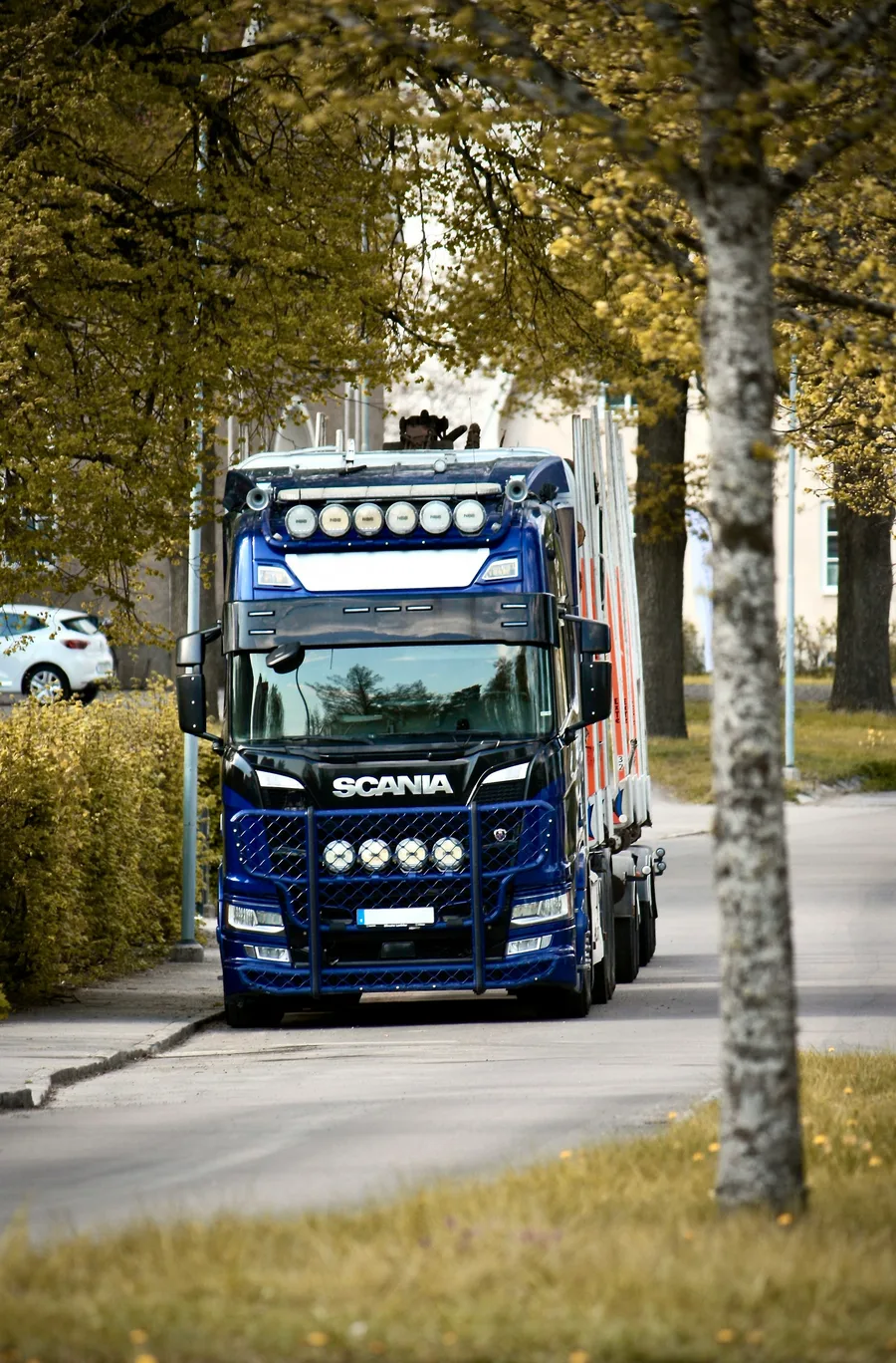 European articulated lorry with trailer on a tree-lined street