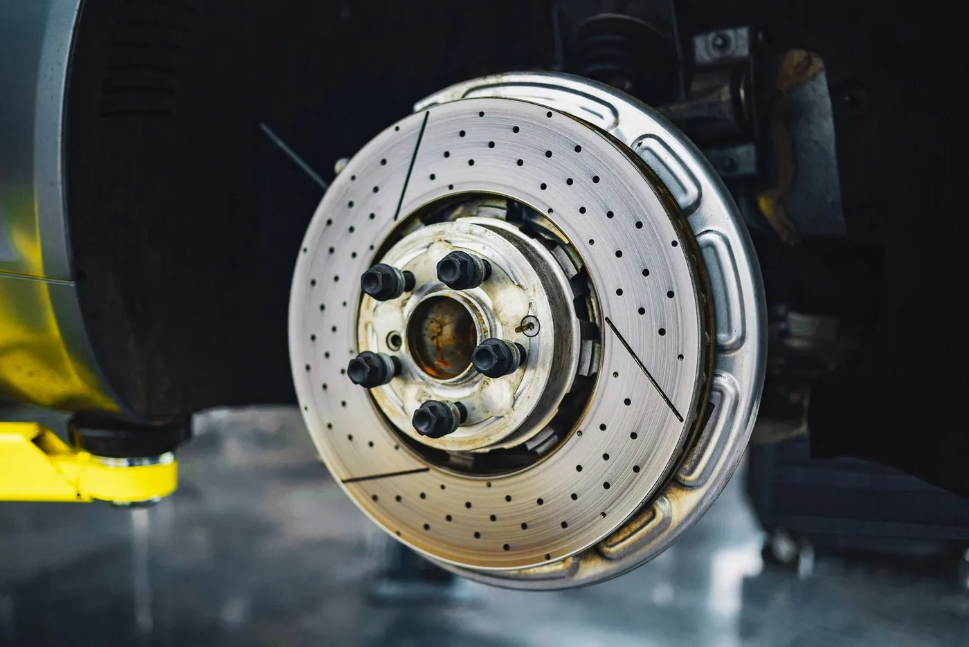 Drilled brake disc being fitted in an automotive workshop